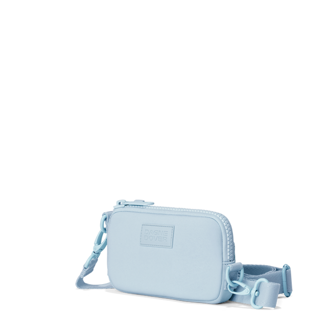 Dagne Dover Mara Phone Sling in an airy, lighter sky blue seen from an angle, showing the adjustable shoulder strap drop.
