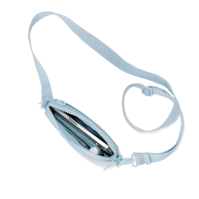 Dagne Dover Mara Phone Sling unzipped in an airy, lighter sky blue seen from above, exposing the interior card slots. hover

