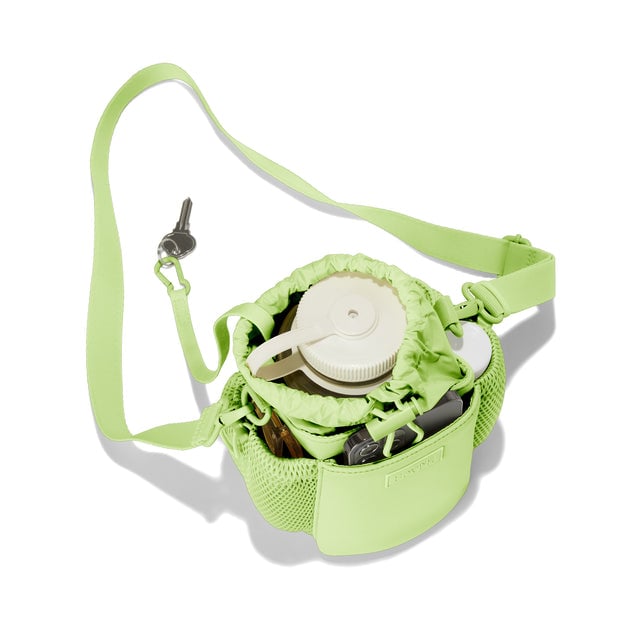 Dagne Dover Sloan Water Bottle Sling in a vibrant, creamy green seen from above containing a water bottle and accessories. hover