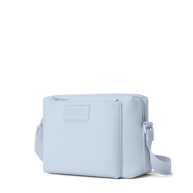 Dagne Dover Micah crossbody in an airy, lighter sky blue seen from an angle.
