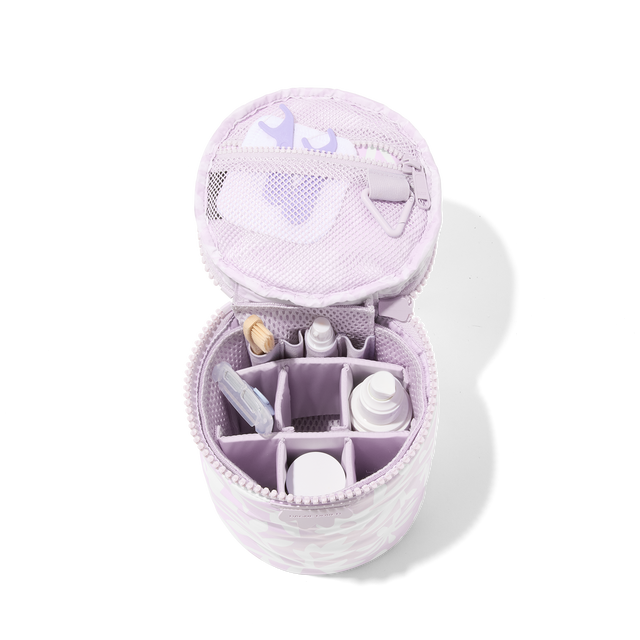 Dagne Dover large Mila Toiletry Pouch in a custom washed lilac and cream floral print unzipped filled with toiletry products. hover
