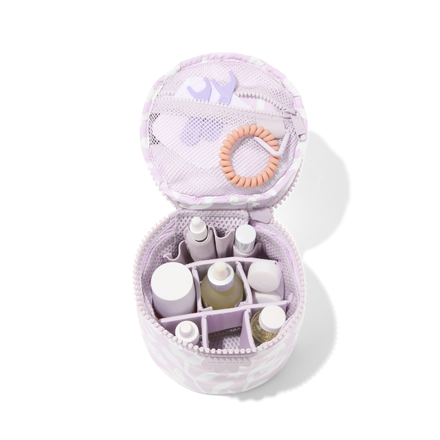 Dagne Dover small Mila Toiletry Pouch in a custom washed lilac and cream floral print unzipped filled with toiletry products. hover
