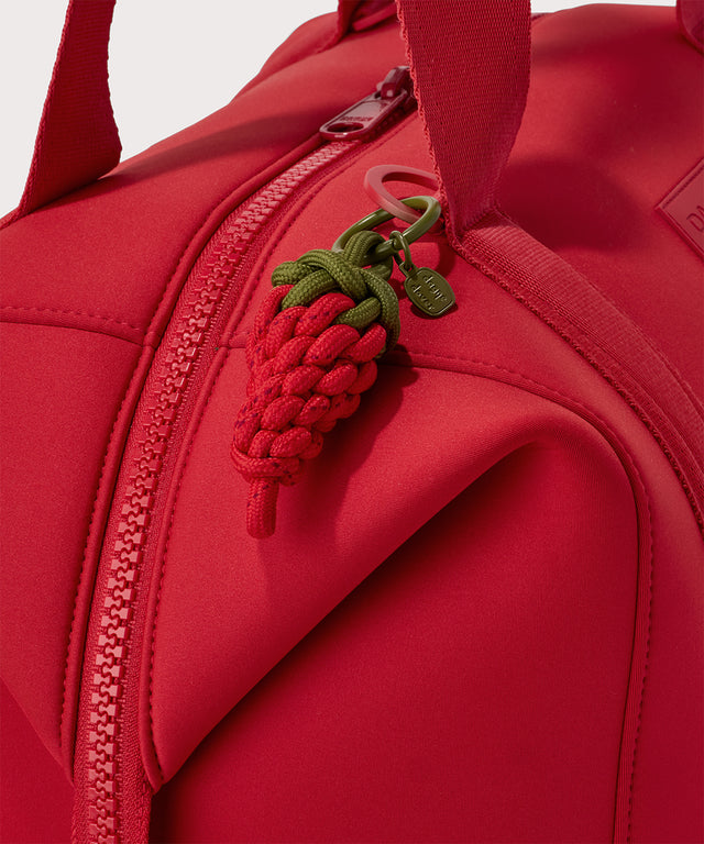 Dagne Dover Picante Keychain in a fiery, saturated red leaning toward orange clipped onto a bag.