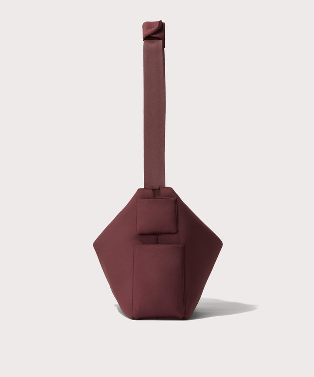 Large Shoulder bag in a deep brown with purple undertones reminiscent of maroon seen from the side view showing phone pocket.
