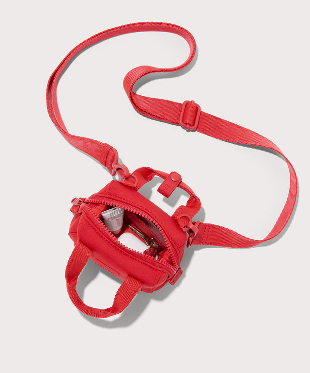 Dagne Dover Micro Landon Crossbody in a fiery, saturated red leaning toward orange unzipped, showcasing the interior.