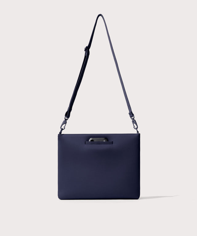 14 inch laptop shoulder bag in navy blue  seen from the back view showing phone pocket.
