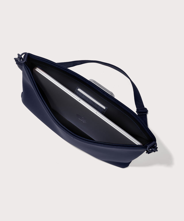 16 inch laptop shoulder bag in a navy blue  seen from the top down view showing interior.
