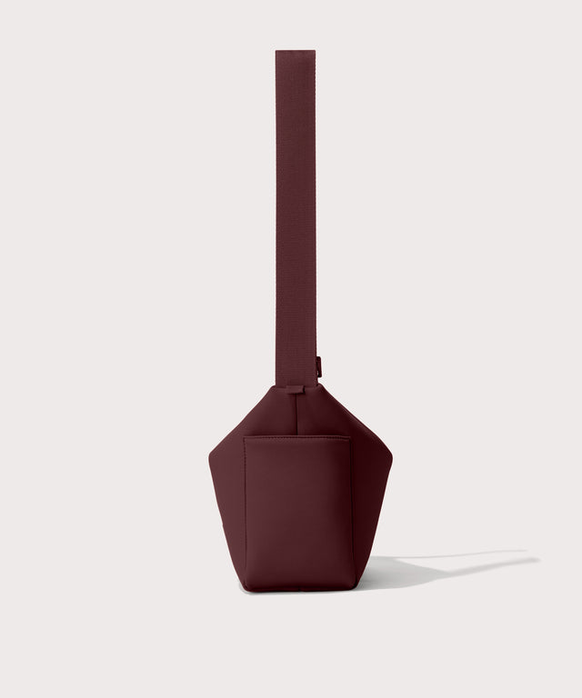 Shoulder bag in a fiery,  deep brown with purple undertones reminiscent of maroon seen from the side view showing phone pocket.