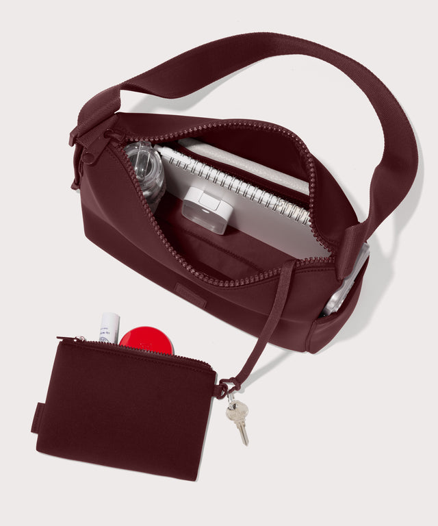 Shoulder bag in a A deep brown with purple undertones reminiscent of maroon seen from the top down view showing interior mesh pouch.
