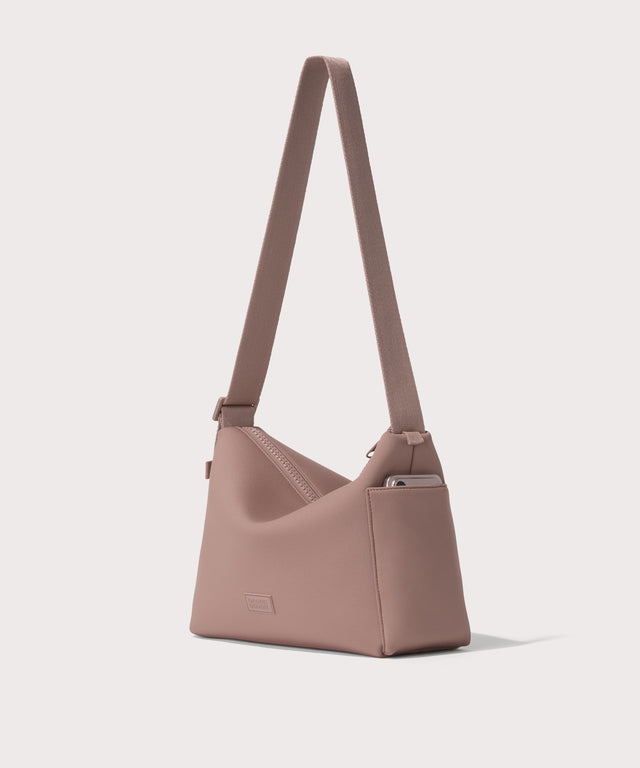 Shoulder bag in a pink seen from the angle view showing phone pocket.
