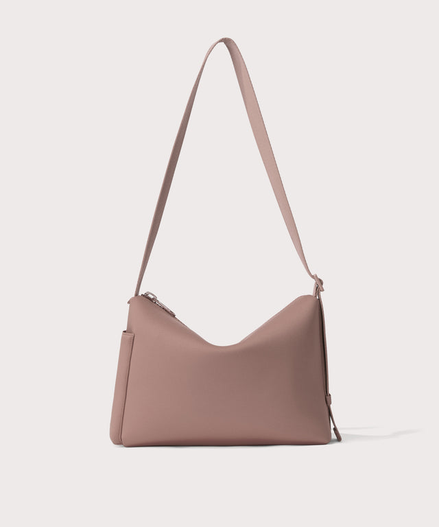 Shoulder bag in a  pink seen from the back view showing phone pocket.