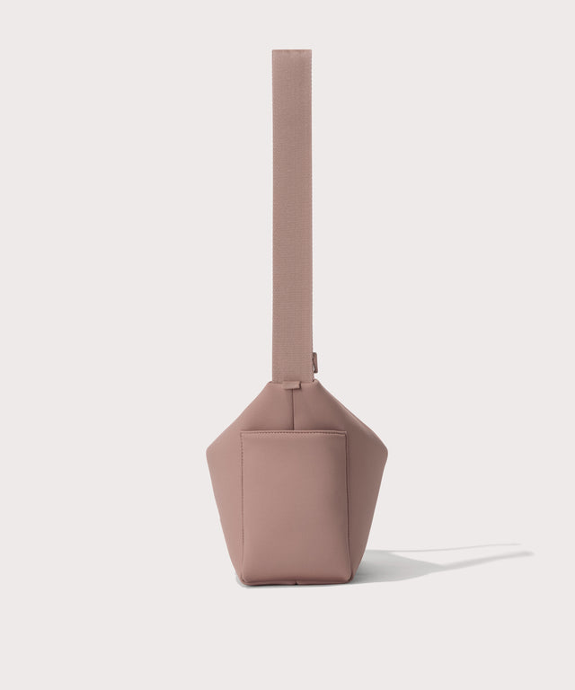 Shoulder bag in a pink seen from the side view showing phone pocket.
