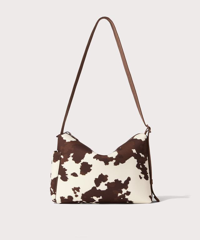 Shoulder bag in a cow print seen from the back view. 