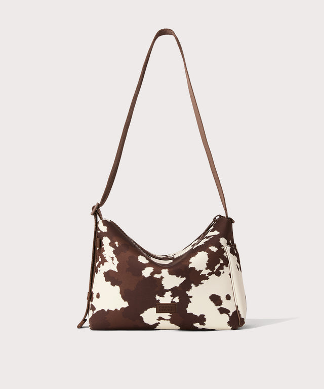 Shoulder bag in a cow print seen from the front view. 