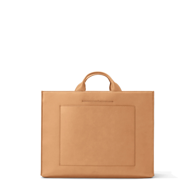 Dagne Dover large vegan Daily Tote in brown revealing the exterior phone pocket and exterior luggage sleeve.