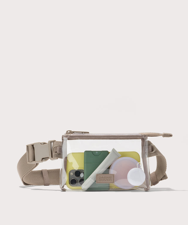 Clear crossbody bag with beige strap on a white background with phone and accessories  Stadium compliant. 