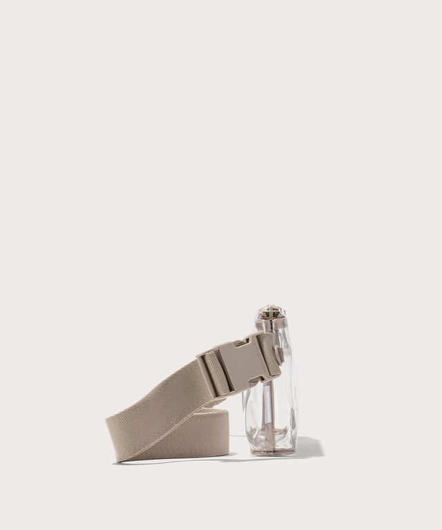 Clear crossbody bag with beige strap on a white background with phone and accessories  Stadium compliant. 