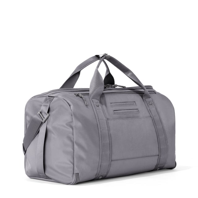 3/4 back view of Monaco garment duffle in ash showing back zippered tech pocket and phone/passport pockets