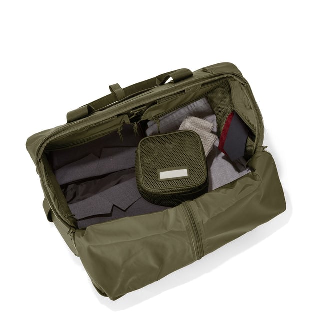 Top down of Monaco garment duffle in dark moss with packing cube on the right side.