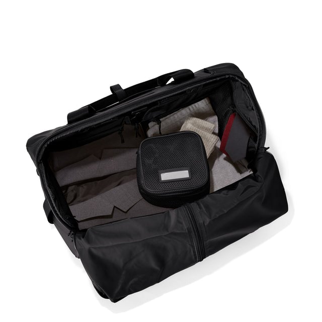 Top down of Monaco garment duffle in onyx with packing cube on the right side.
