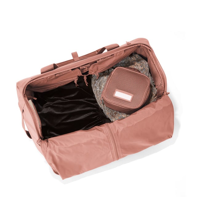 Top down of Monaco garment duffle in warm dust with packing cube on the right side.