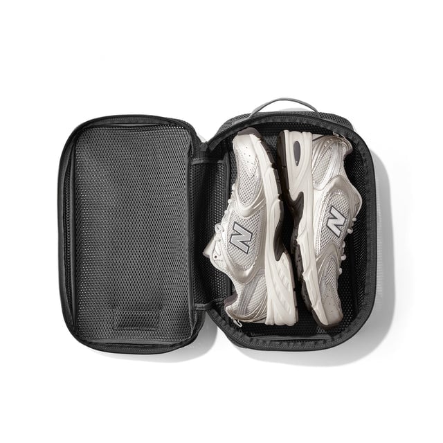 Medium Roma packing cube in carbon grey open with sneakers inside.