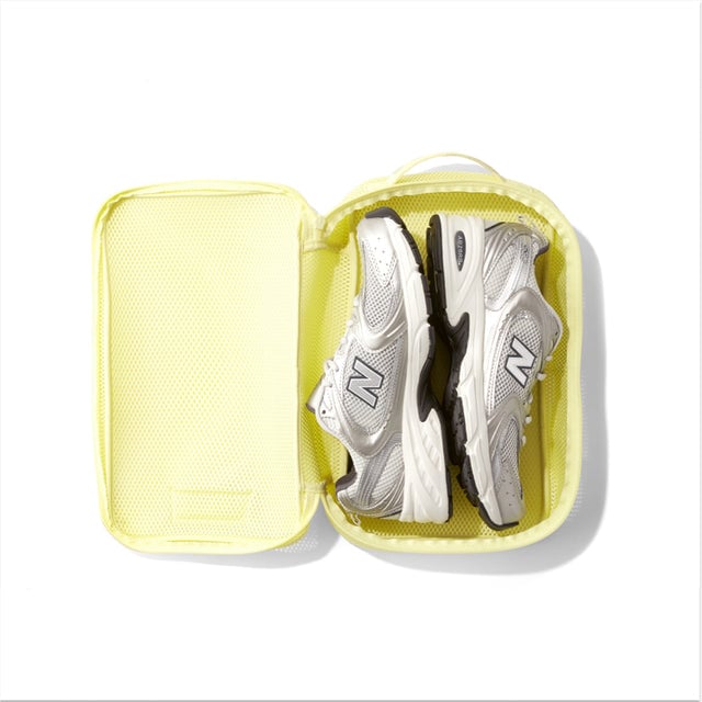 Medium Roma packing cube in citrine yellow open with sneakers inside