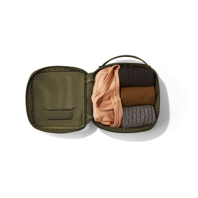 Small Roma packing cube in dark mosst open with socks and a tank top inside.