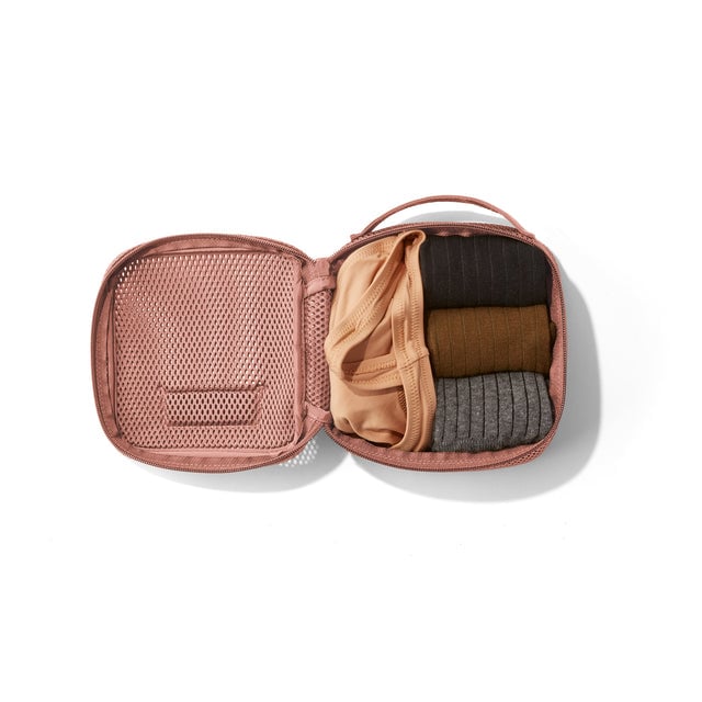 Small Roma packing cube in warm dustt open with socks and a tank top inside. 