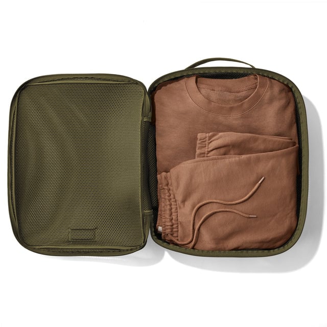 Extra Large Roma packing cube in dark moss open with sweatshirt and sweatpants inside.