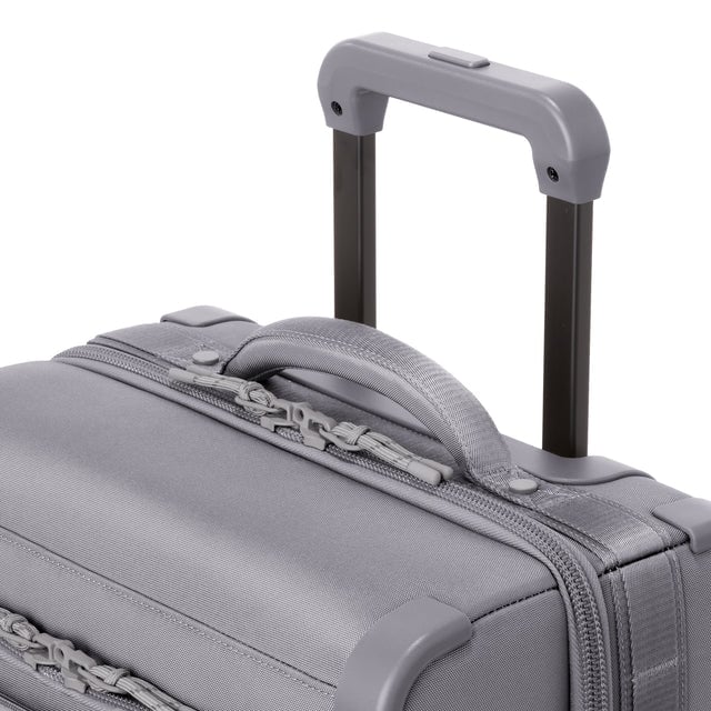 Detail shot of Seattle carry-on rolling luggage 20.5” in ash extended luggage handle and puffy handle
