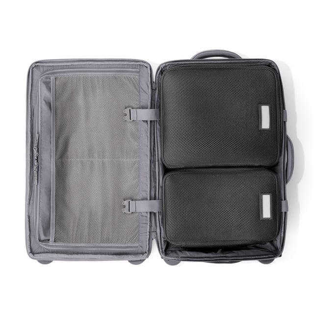 Top down of Seattle carry-on rolling luggage 23.5” in ash with interior divider zipped and packing cubes packed into the right side. Hover