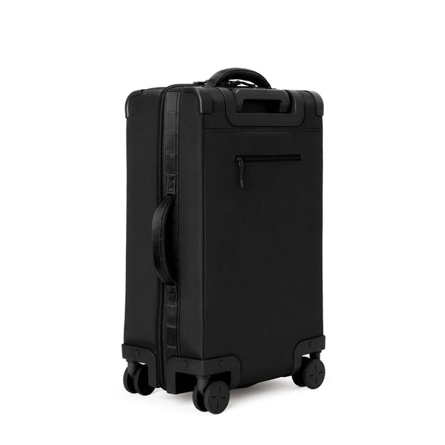3/4 back view of Seattle carry-on rolling luggage 23.5” in onyx showing side handle and back zippered phone/passport pocket