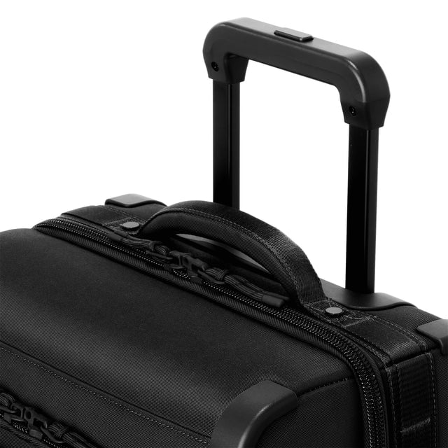 Detail shot of Seattle carry-on rolling luggage 23.5” in onyx extended luggage handle and puffy handle