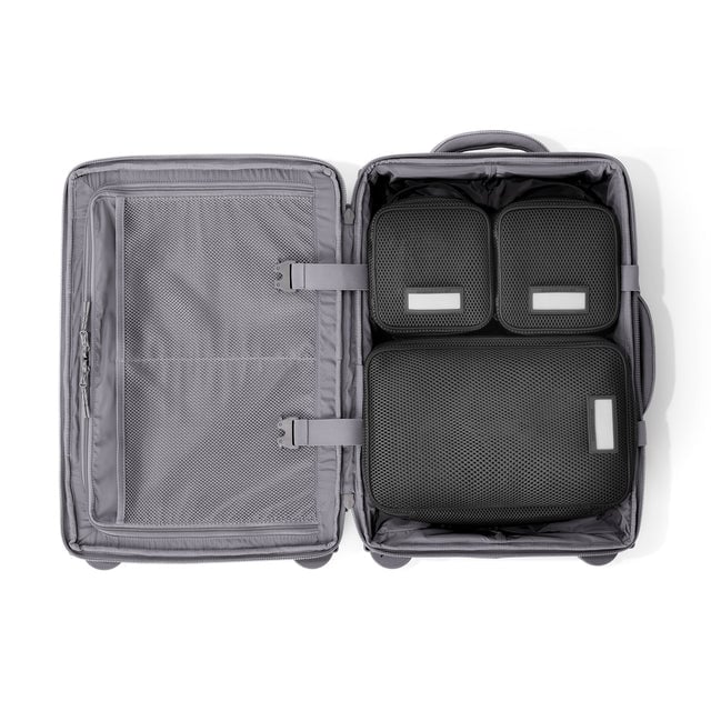 Top down of Seattle carry-on rolling luggage 20.5” in ash with interior divider zipped and packing cubes packed into the right side. Hover