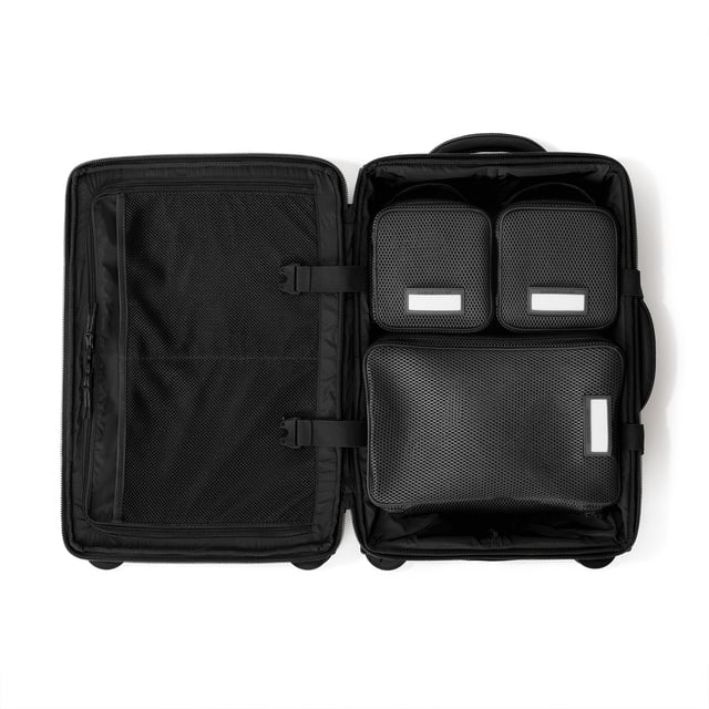 Top down of Seattle carry-on rolling luggage 20.5” in onyx with interior divider zipped and packing cubes packed into the right side. Hover