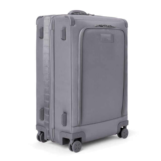 3/4 front view of Sydney checked rolling luggage 28.5” in ash grey showing side luggage feet