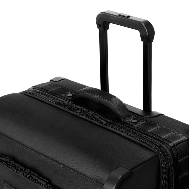 Detail shot of Sydney checked rolling luggage 25” in onyx extended luggage handle and puffy handle