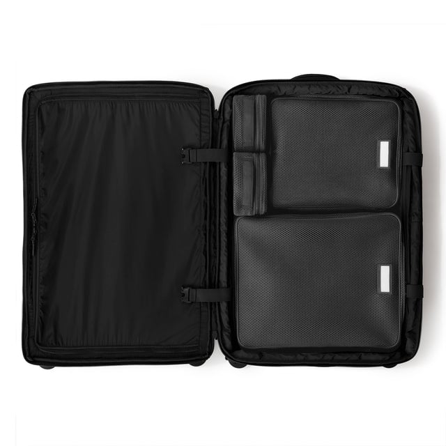 Top down of Sydney checked rolling luggage 28.5” in onyx with interior divider zipped and packing cubes packed into the right side. hover