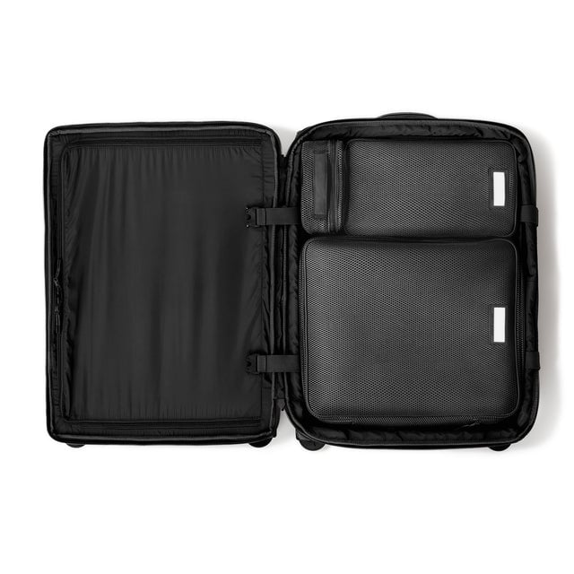 Top down of Sydney checked rolling luggage 25” in onyx with interior divider zipped and packing cubes packed into the right side. hover