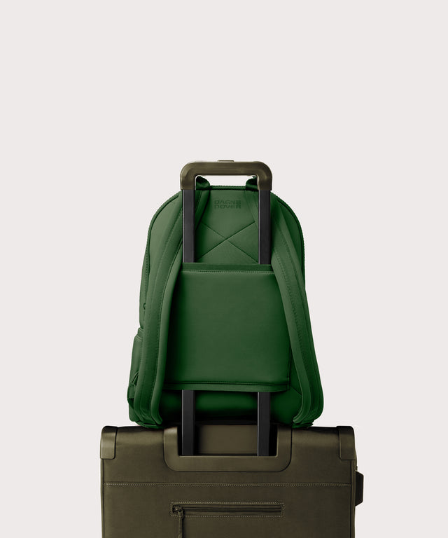 Dagne Dover large Dakota Neoprene Backpack in a rich, classic forest green strapped to luggage with the neoprene luggage-handle sleeve.
