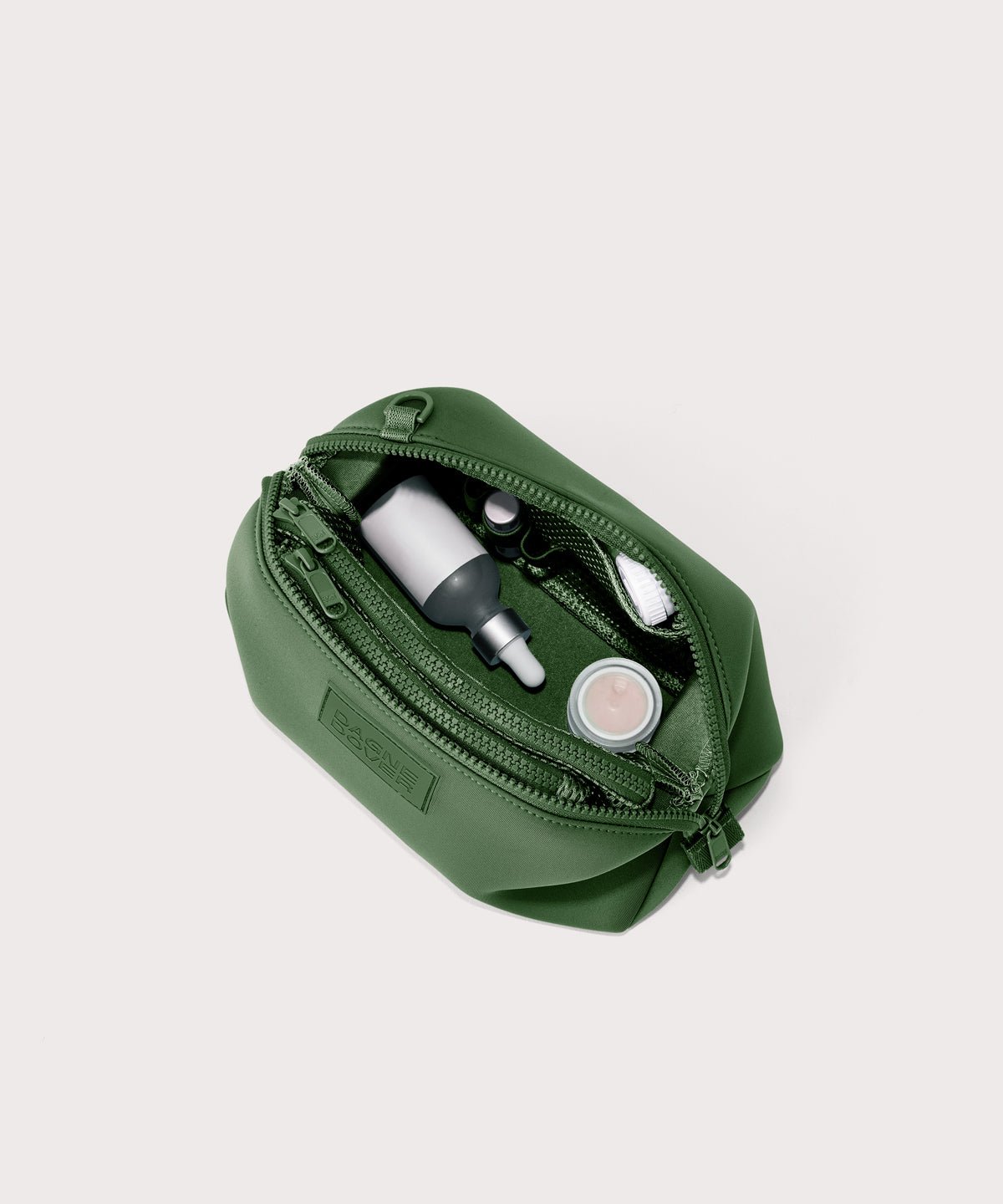 Dagne Dover large Hunter Toiletry Bag in a rich, classic forest green unzipped and seen from above.
