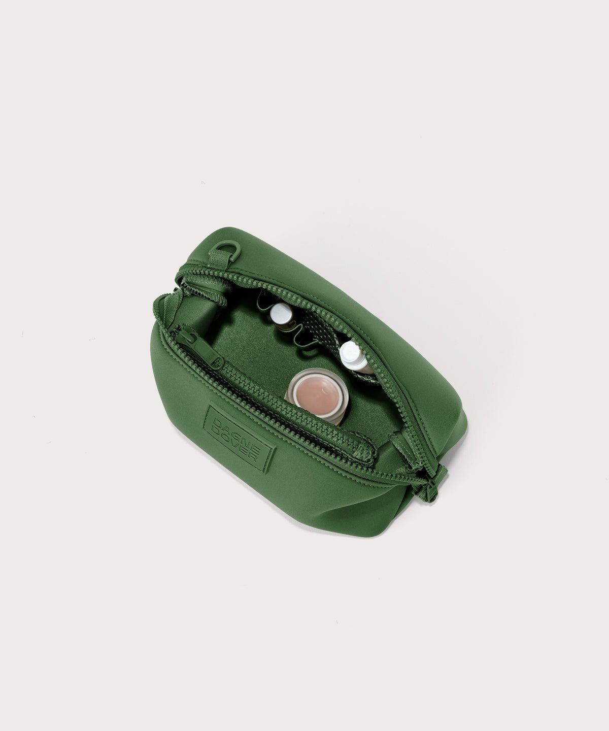 Dagne Dover Small Hunter Toiletry Bag in a rich, classic forest green unzipped and seen from above.
