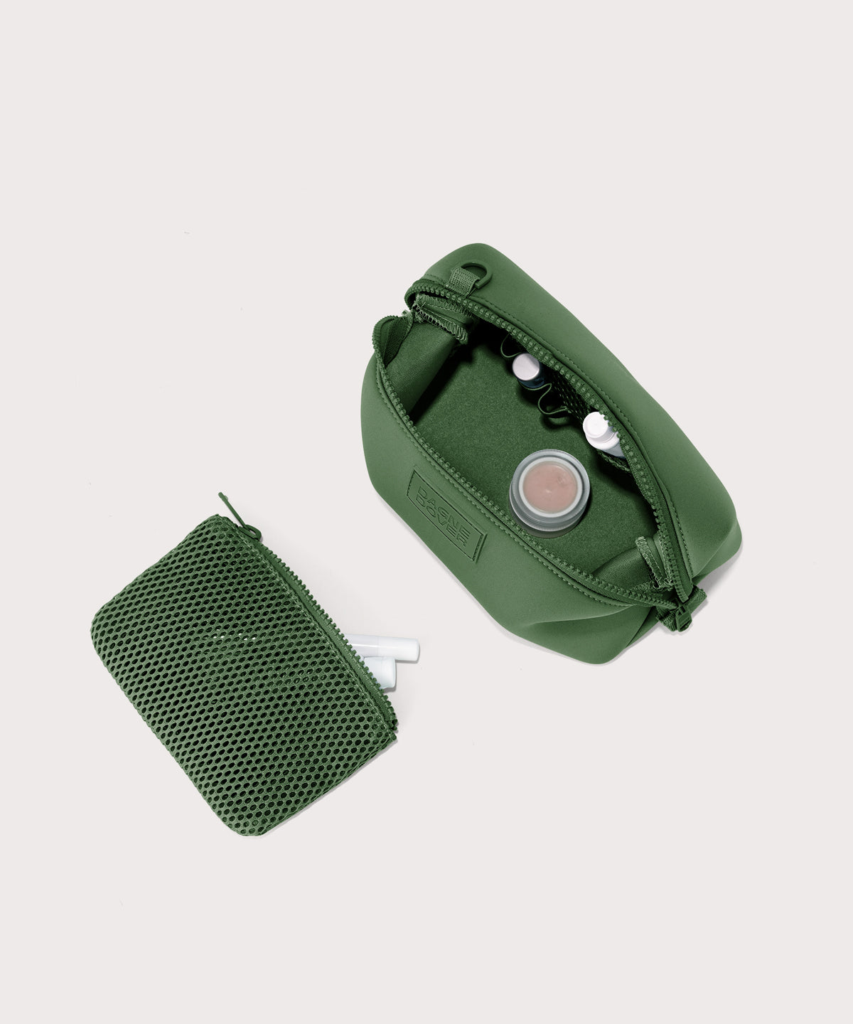 Dagne Dover Small Hunter Toiletry Bag in a rich, classic forest green unzipped and seen from above with the removable air mesh pouch alongside it.