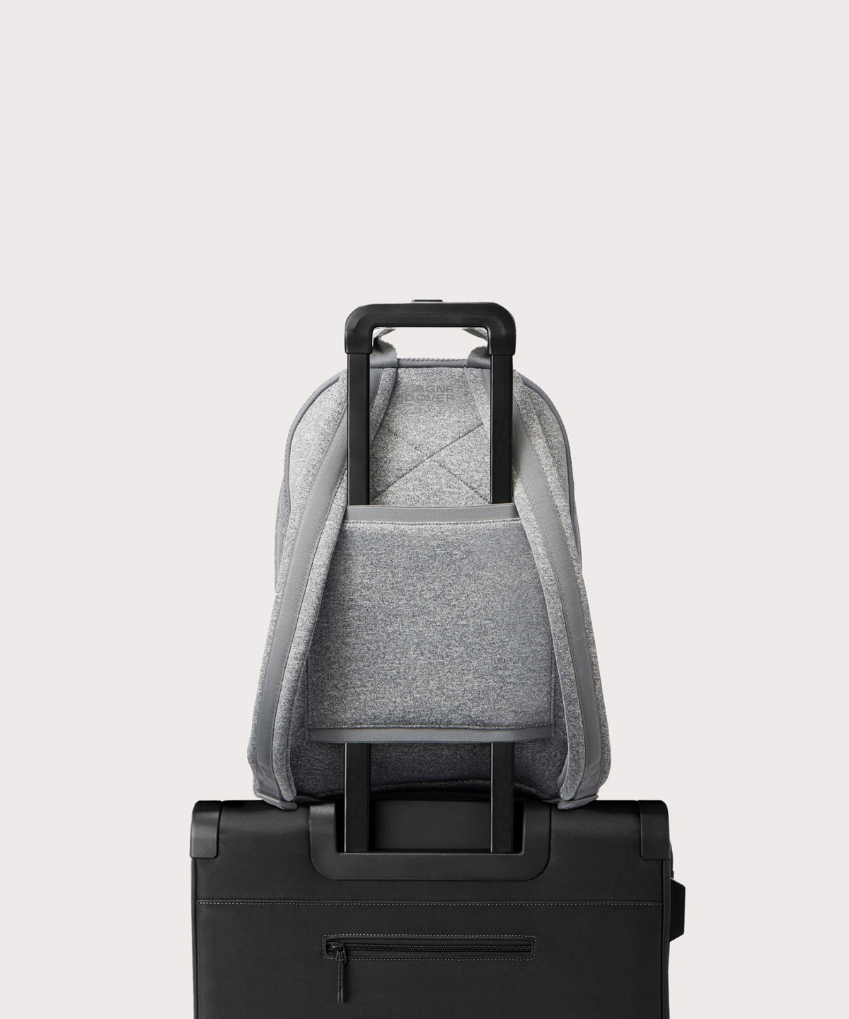 Dagne Dover large Dakota Neoprene Backpack in grey strapped to luggage with the neoprene luggage-handle sleeve.
