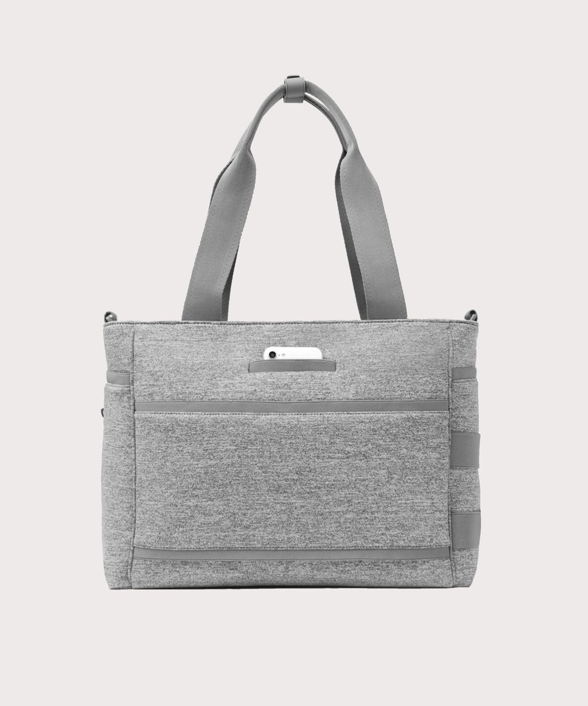 Dagne Dover large Wade Diaper Tote in grey seen from the back with a phone in the exterior phone pocket.
