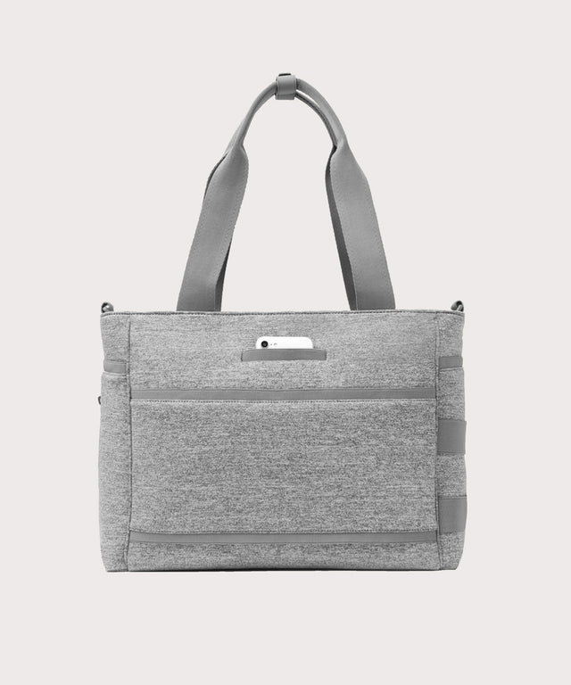 Dagne Dover large Wade Diaper Tote in grey seen from the back with a phone in the exterior phone pocket.
