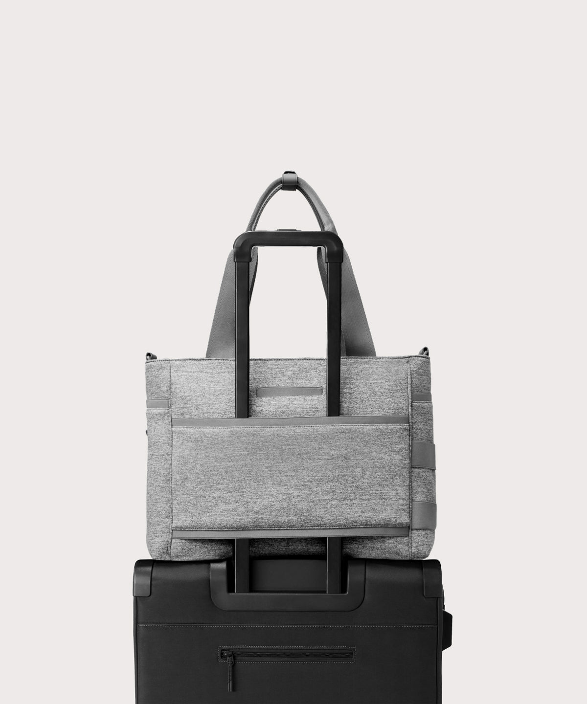 Dagne Dover large Wade Diaper Tote in grey with the neoprene luggage sleeve attached to a suitcase handle.
