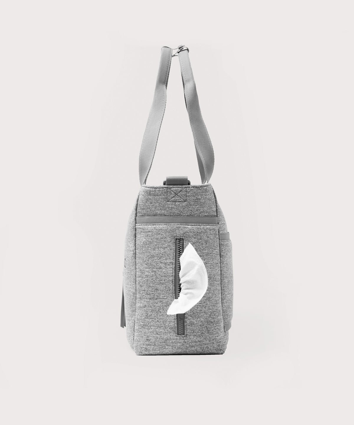 Dagne Dover large Wade Diaper Tote in grey seen from the side, with a wet wipe poking out of the slip pocket.
