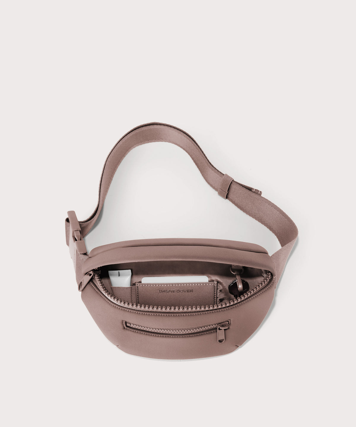 Dagne Dover Ace Fanny Pack in  pink  unzipped, exposing the interior pockets

